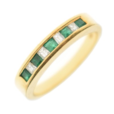 Lot 7 - Emerald and diamond yellow metal half eternity ring