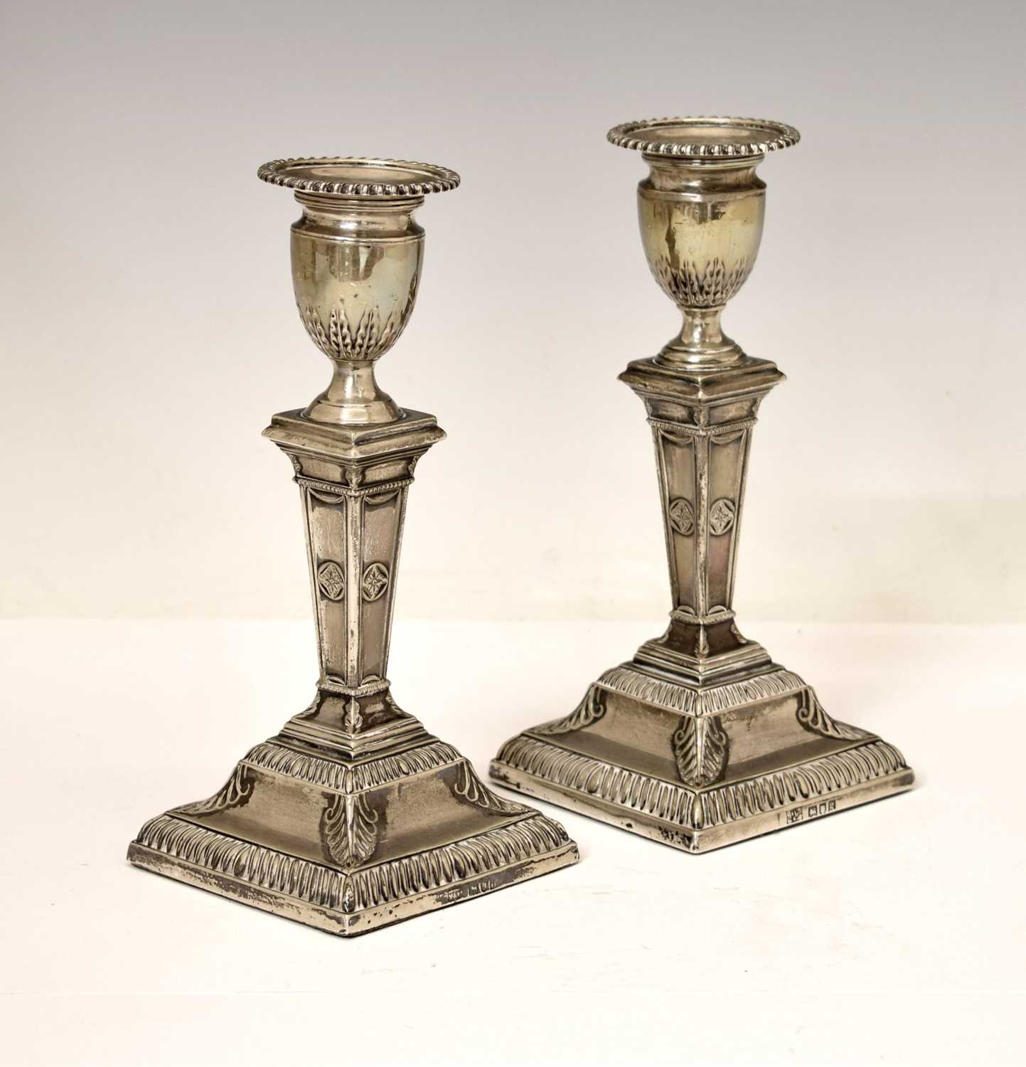 Lot 159 - Pair of silver candlesticks in the neoclassical taste of square columner form