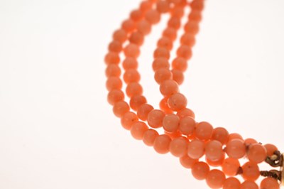Lot 180 - Coral four-strand bracelet with French gold and green enamel clasp