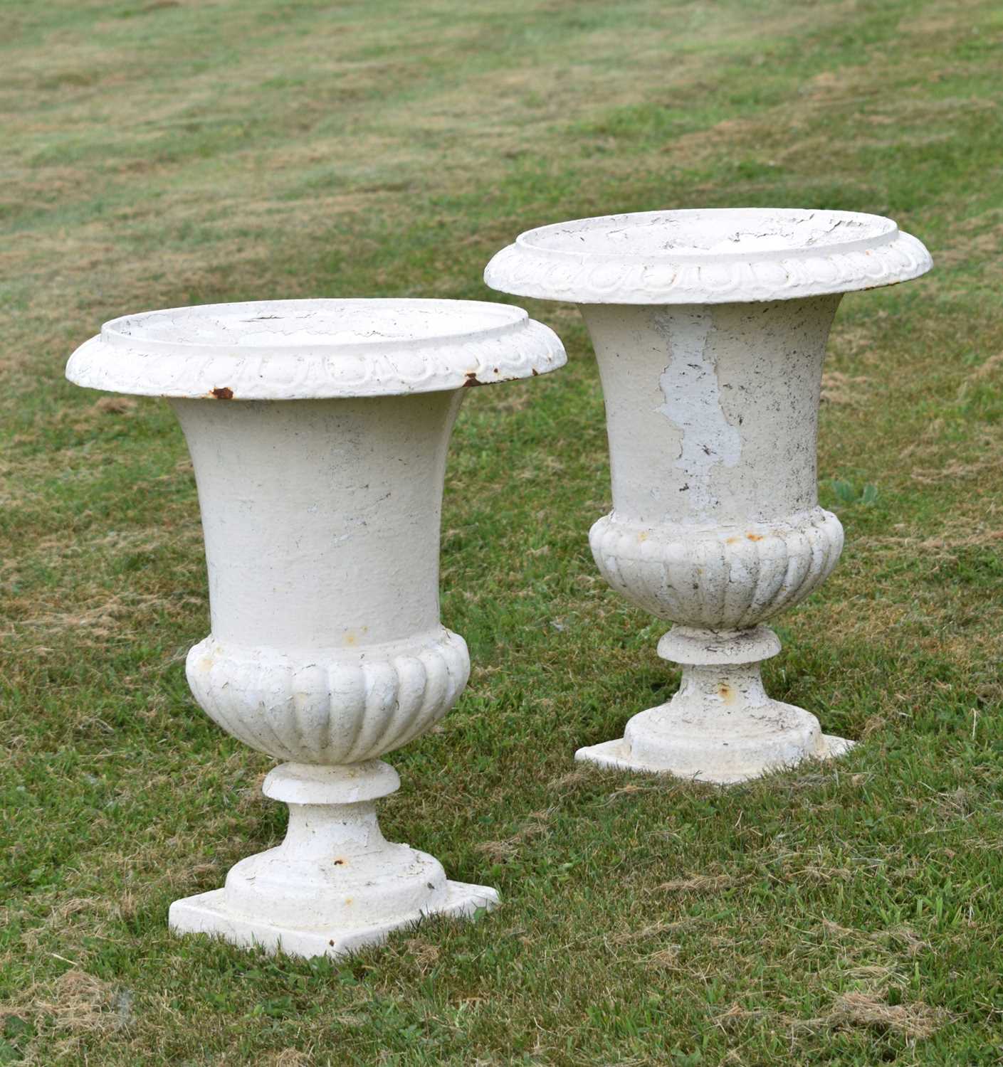 Lot 210 - Pair of white-painted cast iron garden urns