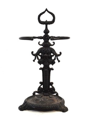 Lot 501 - Cast iron stick stand, having mask and floral decoration