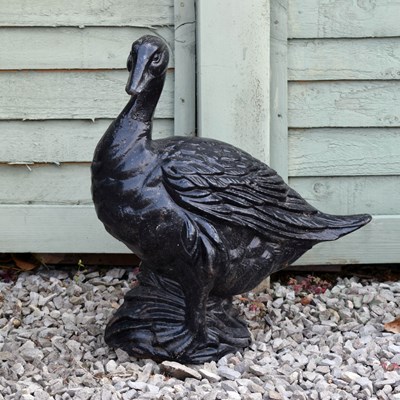 Lot 566 - Black painted cast iron decorative goose perched upon a rock