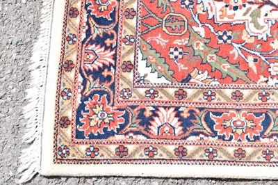 Lot 517 - Machine made cream and red ground wool rug