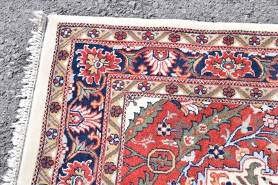 Lot 517 - Machine made cream and red ground wool rug