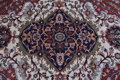 Lot 517 - Machine made cream and red ground wool rug