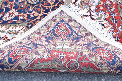 Lot 517 - Machine made cream and red ground wool rug
