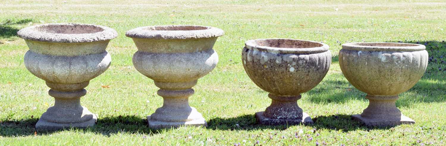 Lot 553 - Two pairs of composition stone garden urns / planters