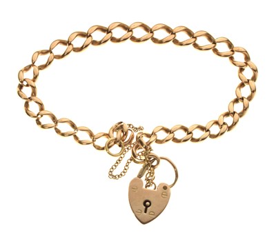 Lot 172 - Unmarked yellow metal ('rose gold') flat curb link bracelet with safety chain and heart padlock, 14g