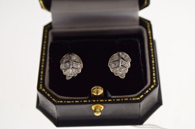 Lot 65 - Pair of unmarked white metal leaf design diamond set stud earrings