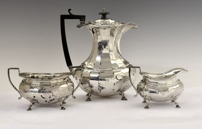 Lot 159 - George V silver four-piece tea set of shaped form and standing on four hoof feet