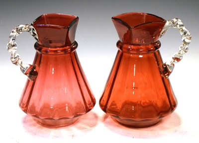 Lot 250 - Pair of cranberry glass ewers