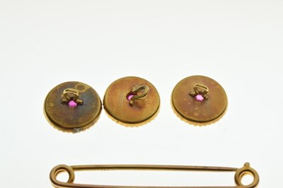 Lot 21 - Three yellow metal (9ct) ruby-set buttons