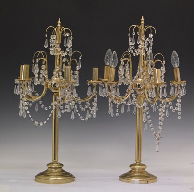 Lot 581 - Pair of brass electric candelabra with lustre drop decoration