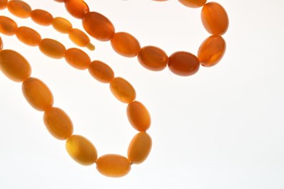 Lot 77 - Two graduated amber bead necklaces, and a pair of amber set cufflinks