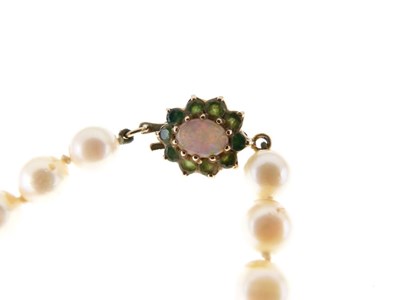 Lot 50 - Row of uniform cultured pearls on 9ct opal and emerald clasp